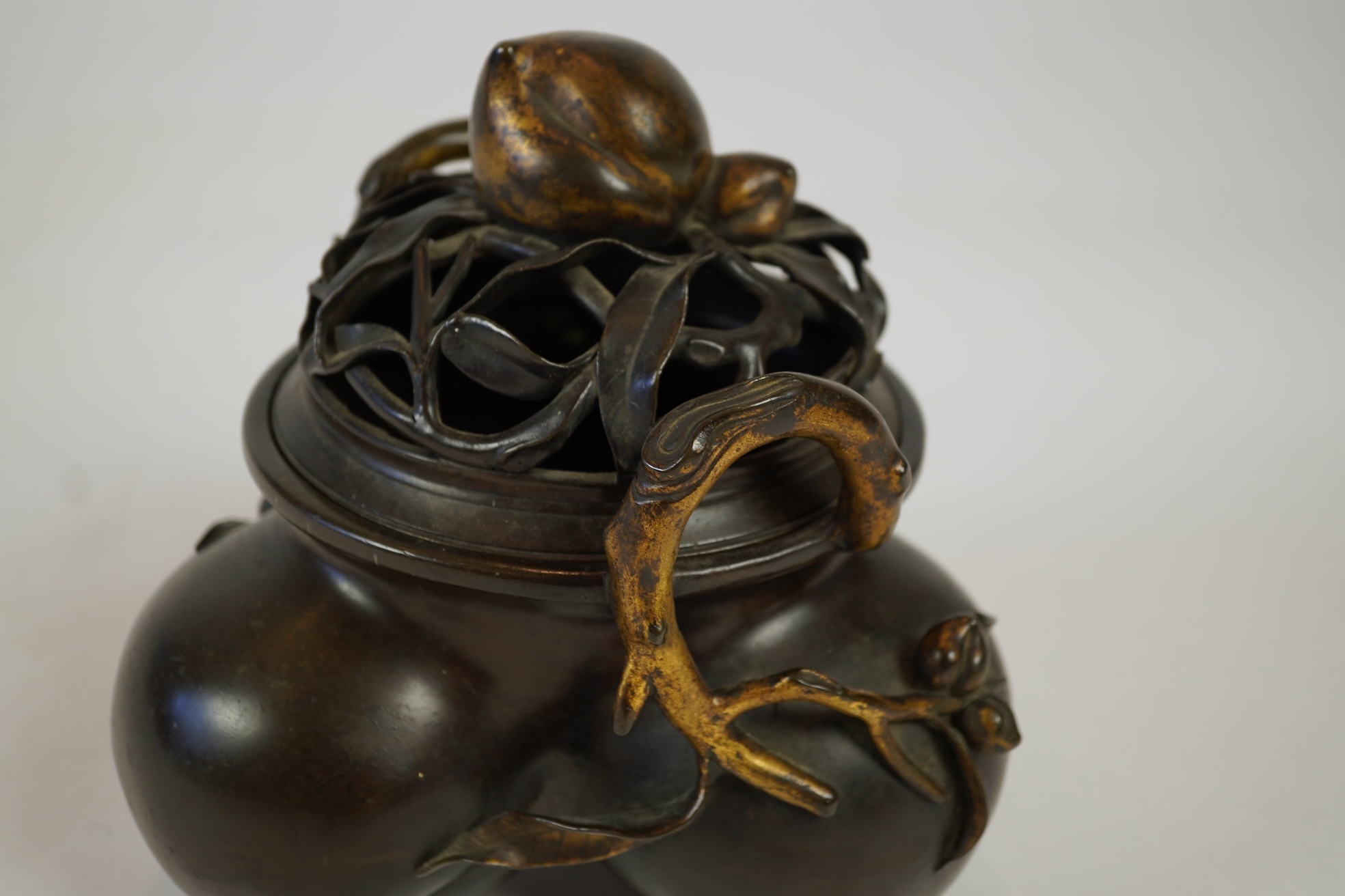 A large Chinese bronze and parcel gilt ‘peach’ censer and cover, Li, 17th/18th century